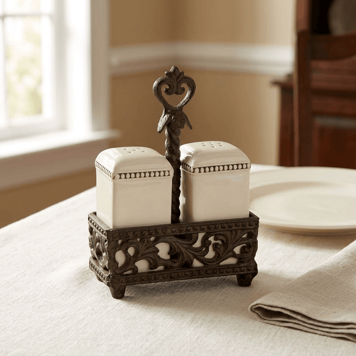 Bellavita cream ceramic salt and pepper set styled on an ivory linen dining table beside a plate and napkin.