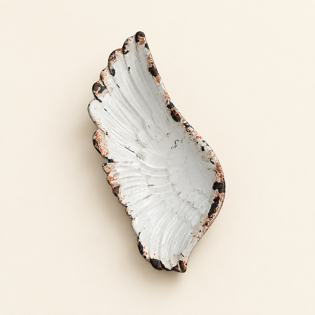 Rustic white pewter angel wing jewelry tray with sculpted feather details on an ivory background
