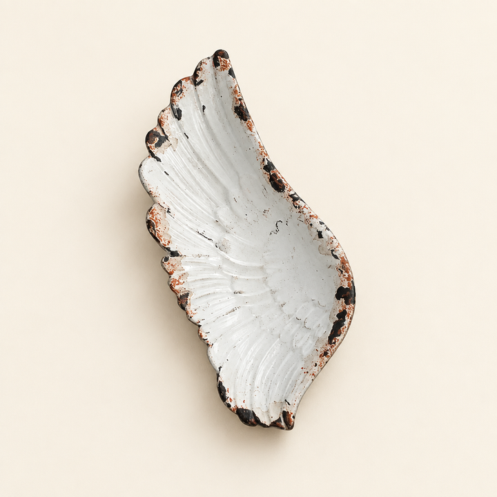 Rustic white pewter angel wing jewelry tray with sculpted feather details on an ivory background