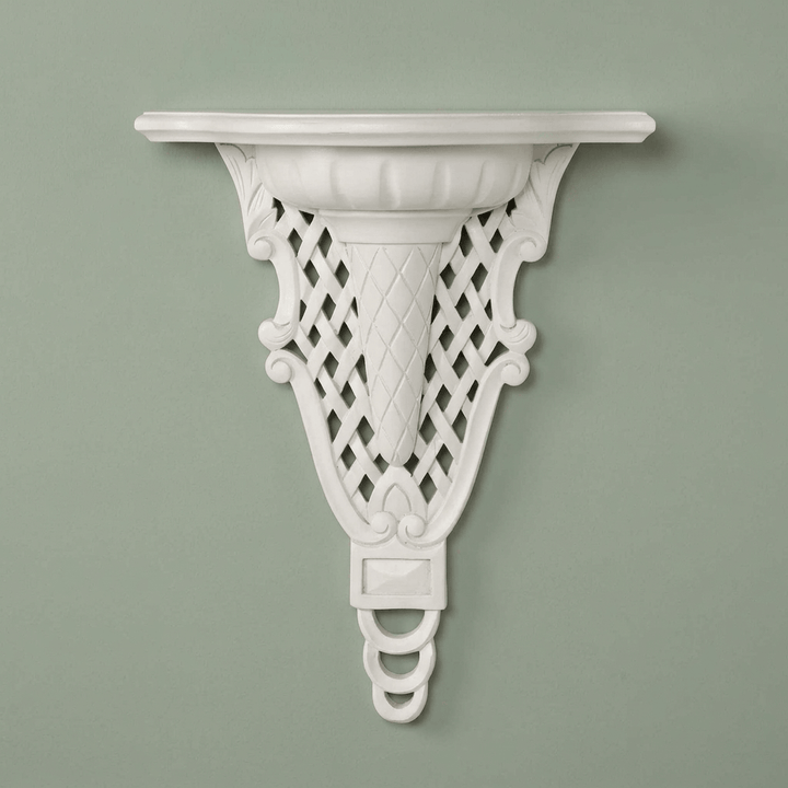 Front view of white Avelisse Wall Ledge showing diamond latticework against a sage wall.