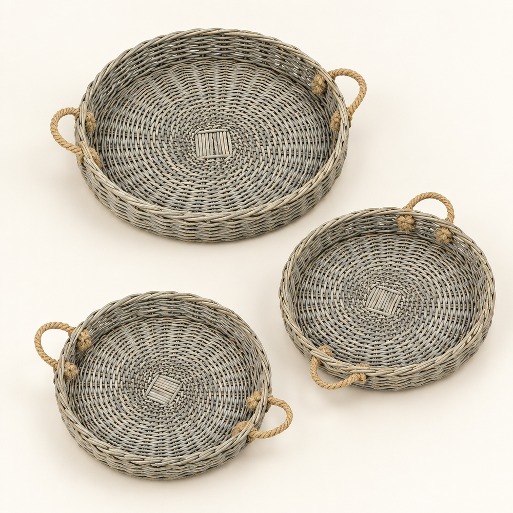 Three grey-washed round willow trays with jute handles on an ivory background