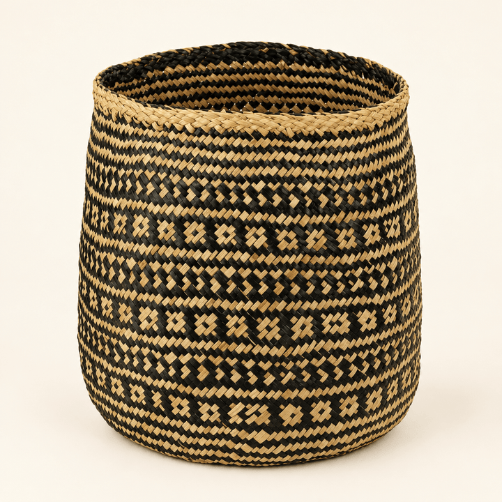 Black and natural geometric seagrass storage basket on an ivory studio background.