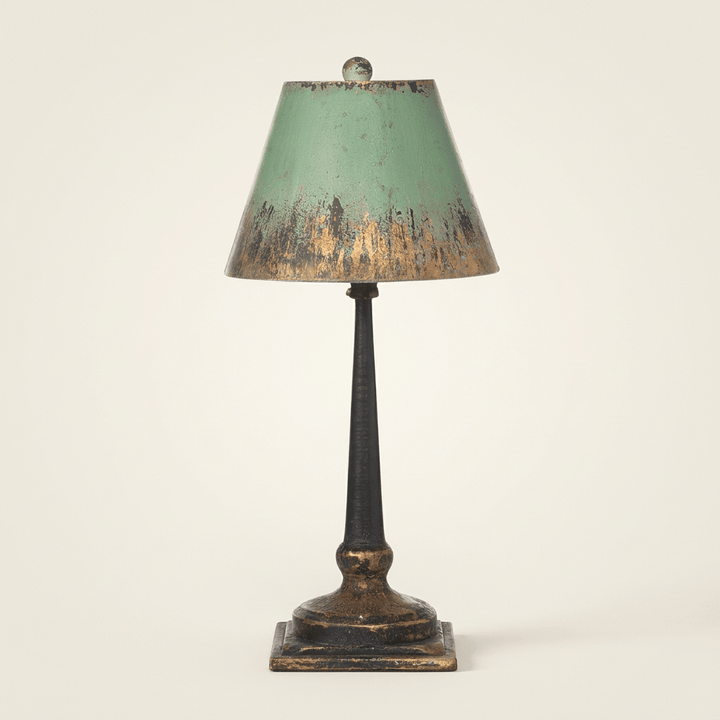 Studio view of Adeline distressed green and gold table lamp on an off-white background