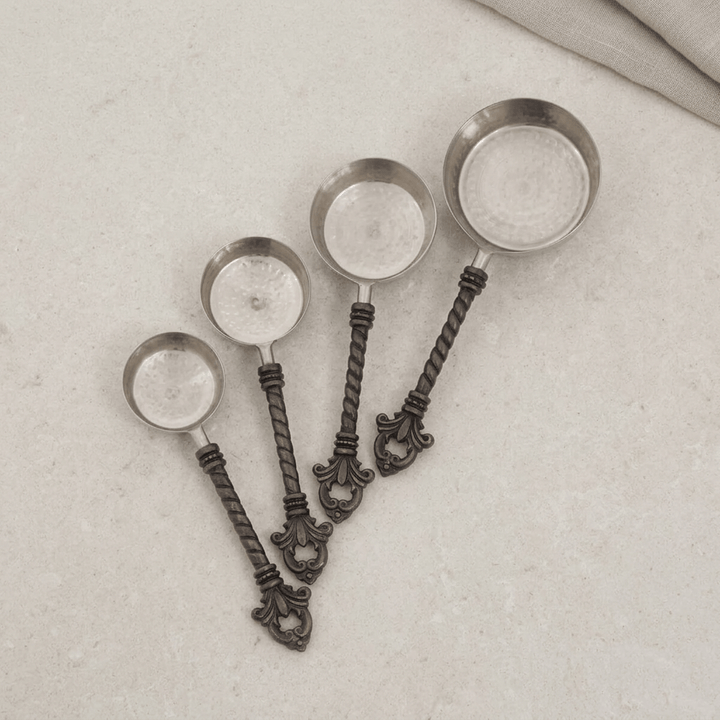 Top-down view of four Bellavita measuring cups on pale stone, matching the original product view