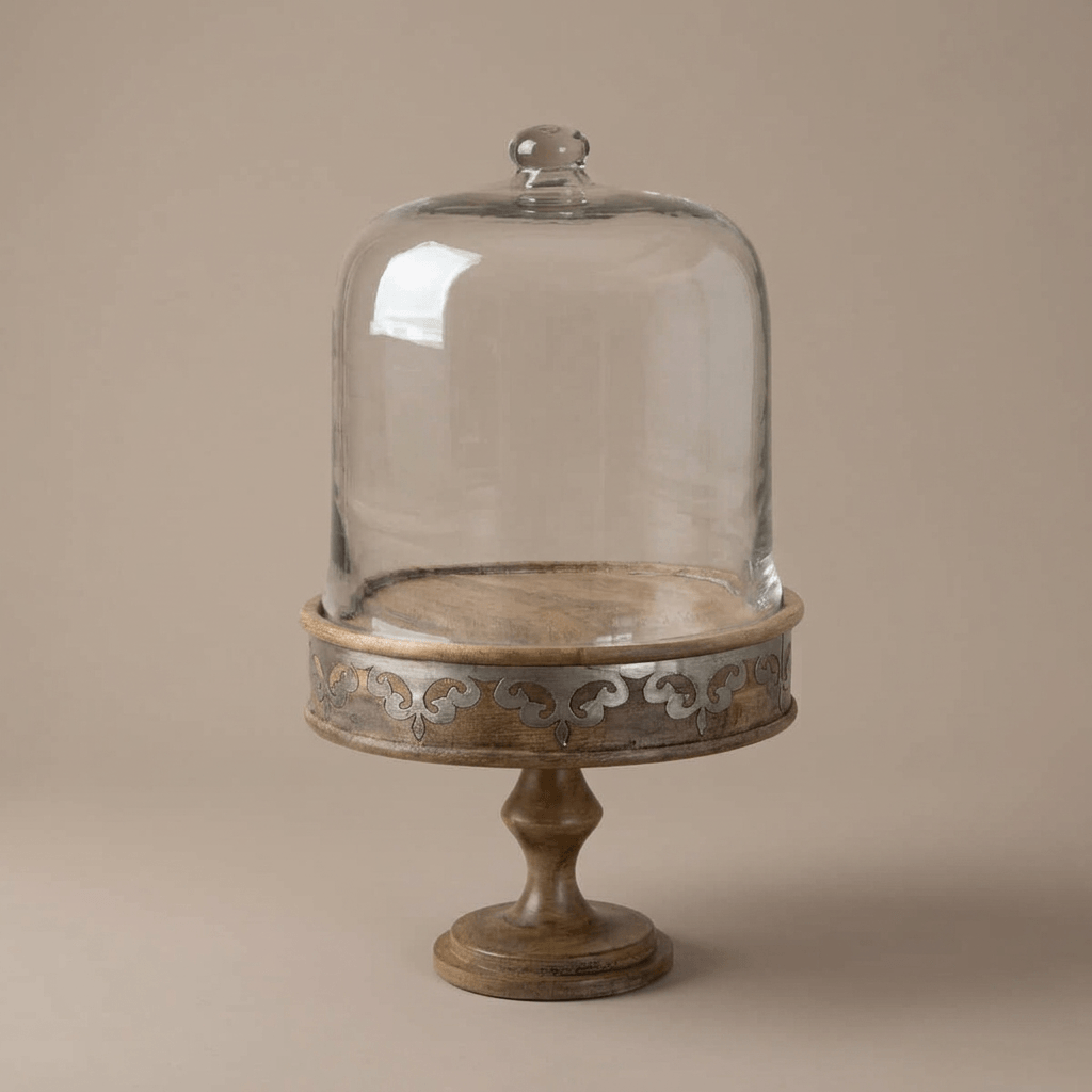 Belvedere Cake Pedestal with Glass Dome showing its shaped stem and metal inlay against taupe.
