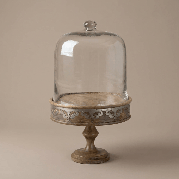Belvedere Cake Pedestal with Glass Dome showing its shaped stem and metal inlay against taupe.