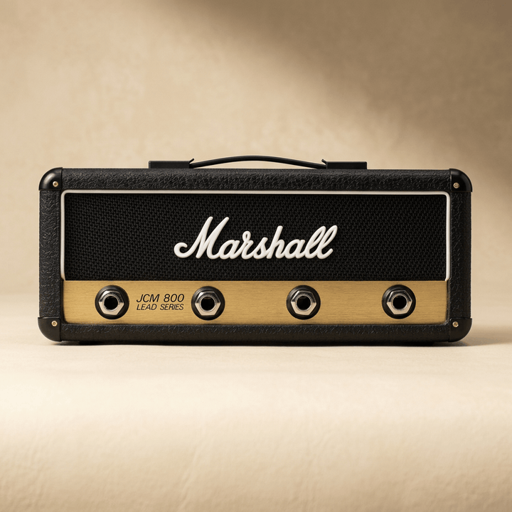 Black and gold Marshall JCM800 Reissue amp key holder with four jack sockets on an ivory background.