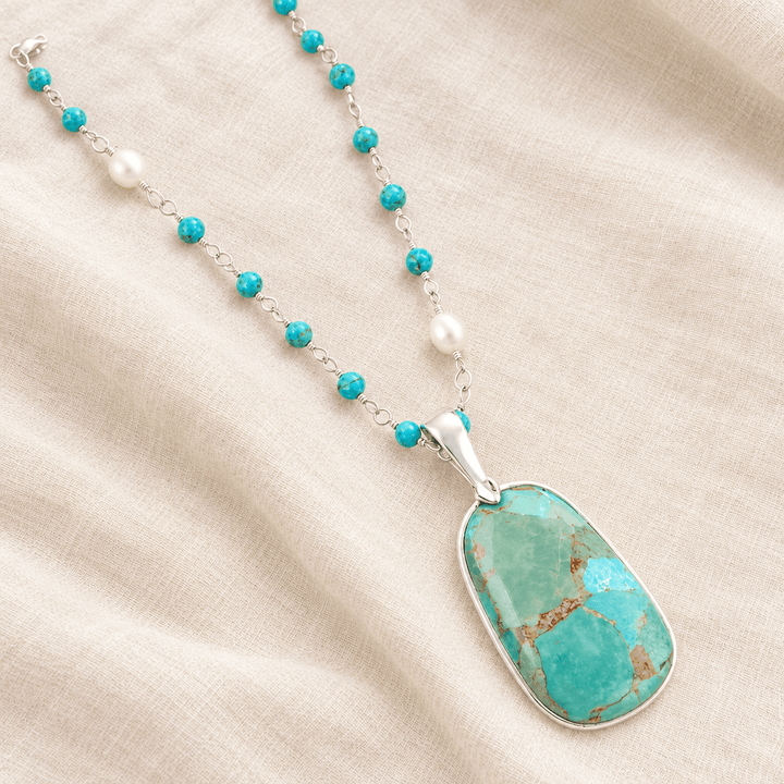 Turquoise and pearl sterling silver pendant necklace styled on ivory linen