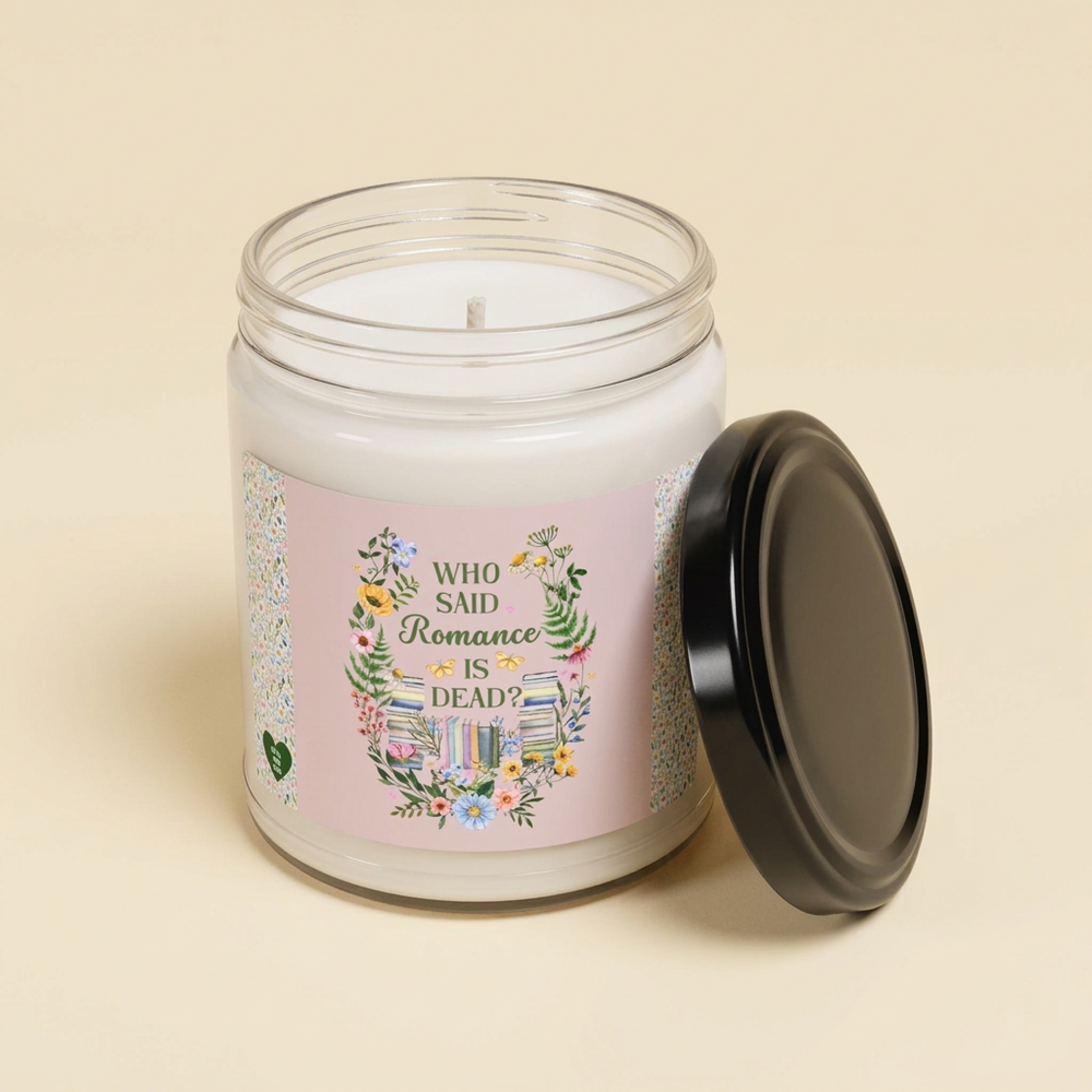 Unlit soy blend candle with pink Who Said Romance Is Dead label and black lid beside the jar on an ivory background.