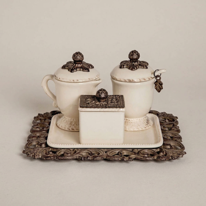 Bellavita cream and sugar set with dark metal finials and scrolling tray on a taupe studio background.