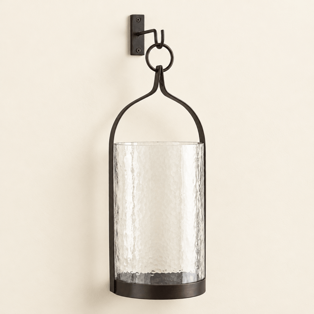 Black and bronze steeple iron lantern with hammered glass sleeve and included wall hook on an ivory wall