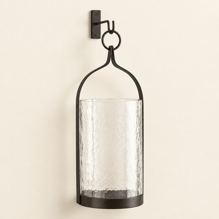 Black and bronze steeple iron lantern with hammered glass sleeve and included wall hook on an ivory wall