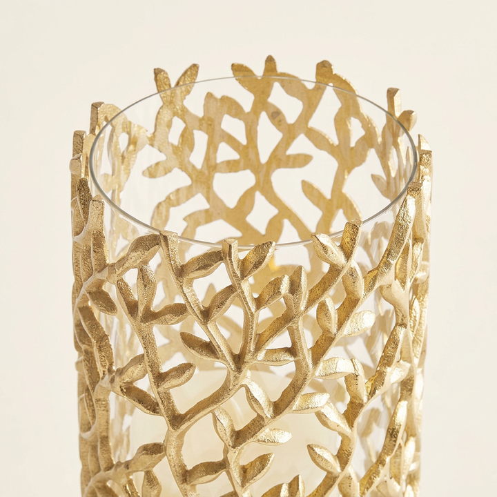 Close-up of gold aluminum leaves and vines surrounding the hurricane candle holder's clear glass rim.