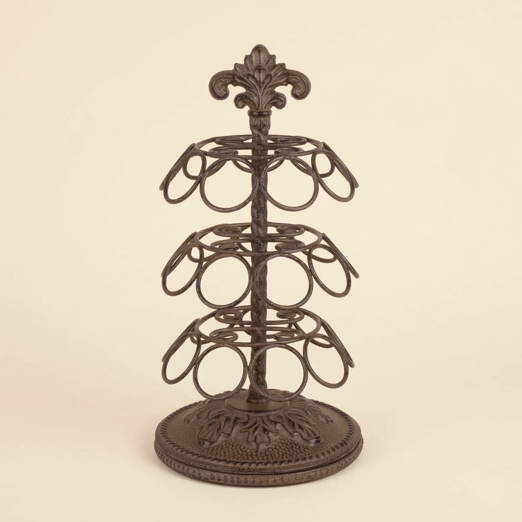 Bellavita Coffee Pod Carousel in dark antique bronze cast metal with three tiers of ring holders and an ornate acanthus crest, on a cream studio backdrop