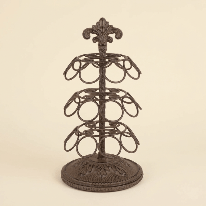 Bellavita Coffee Pod Carousel in dark antique bronze cast metal with three tiers of ring holders and an ornate acanthus crest, on a cream studio backdrop