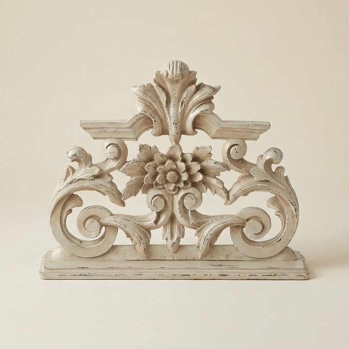 Antique-white floral scroll mantel sculpture with a central flower, open scrolling filigree, and a leafy crest on a neutral background.