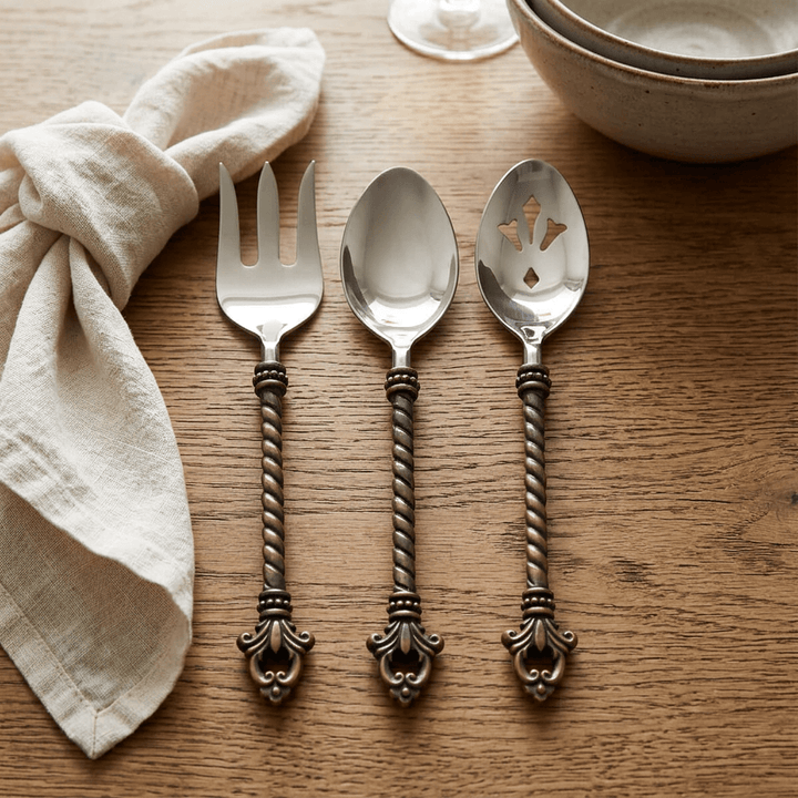 Bellavita three-piece serving set on a warm oak dining table beside cream linen.