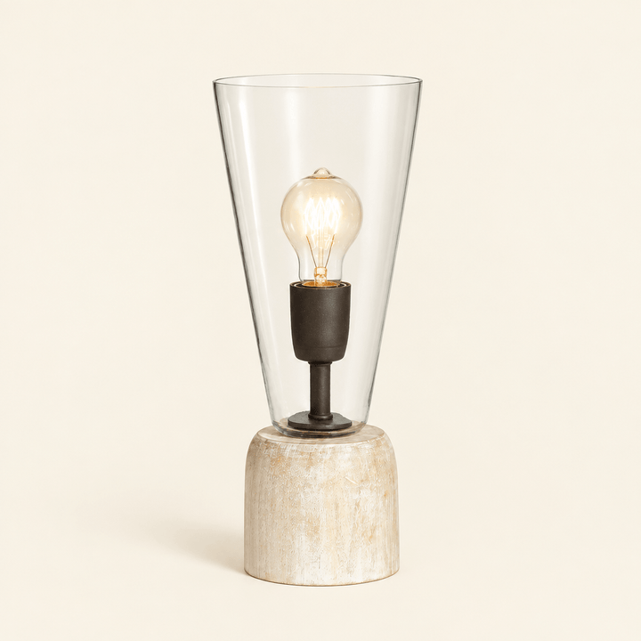 Whitewashed wood mini lamp with tapered clear glass shade and exposed decorative bulb on an ivory background