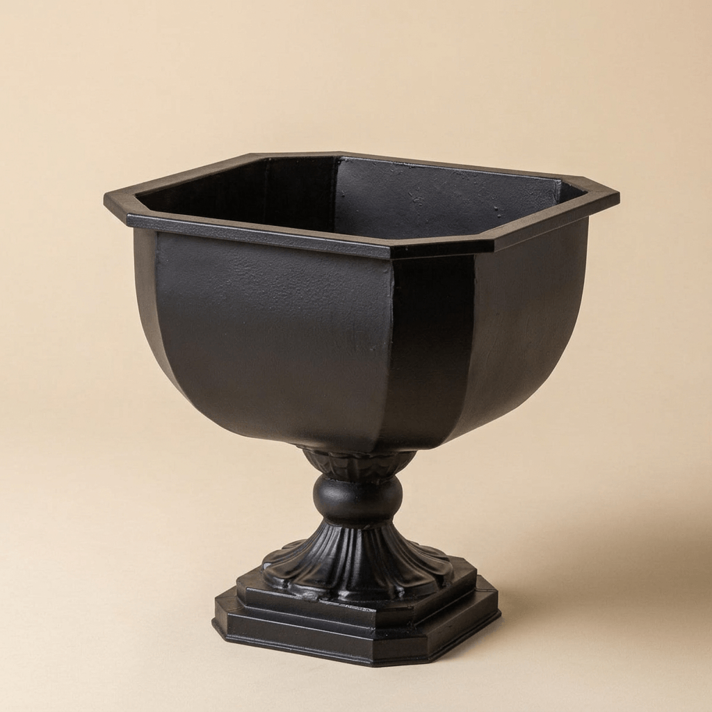Empty Octavia black iron chalice planter showing its octagonal rim, faceted bowl, and fluted pedestal against a beige studio backdrop.