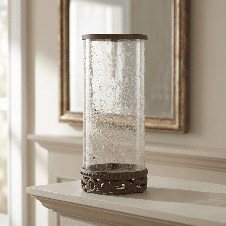 Tall Bellavita Glass Hurricane Candle Holder styled on a pale mantel in front of a mirror.