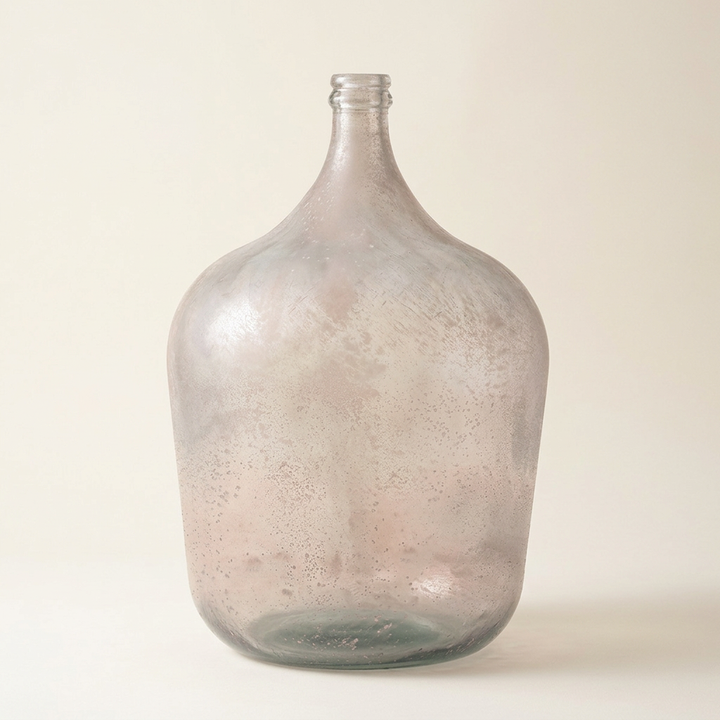 Misted Glass Demijohn Vase with cloudy blush-gray glass and a muted green base on a warm ivory studio background.