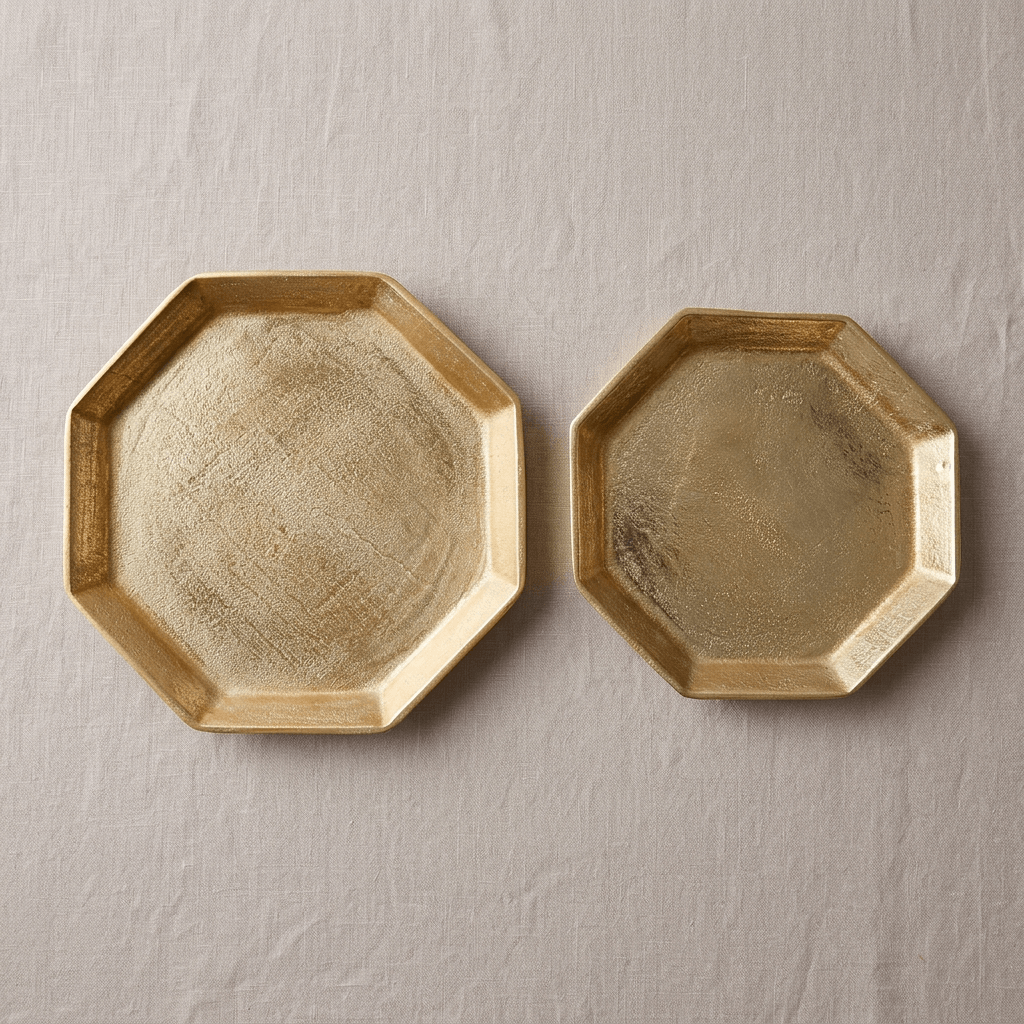 Overhead view of two gold octagonal serving trays showing their textured cast aluminum surfaces and angular rims.