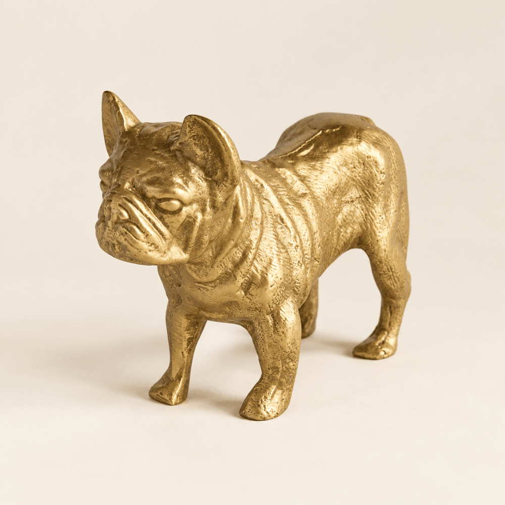 Textured gold bulldog sculpture on a warm ivory studio surface.