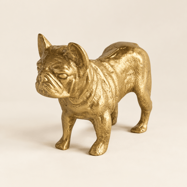 Textured gold bulldog sculpture on a warm ivory studio surface.