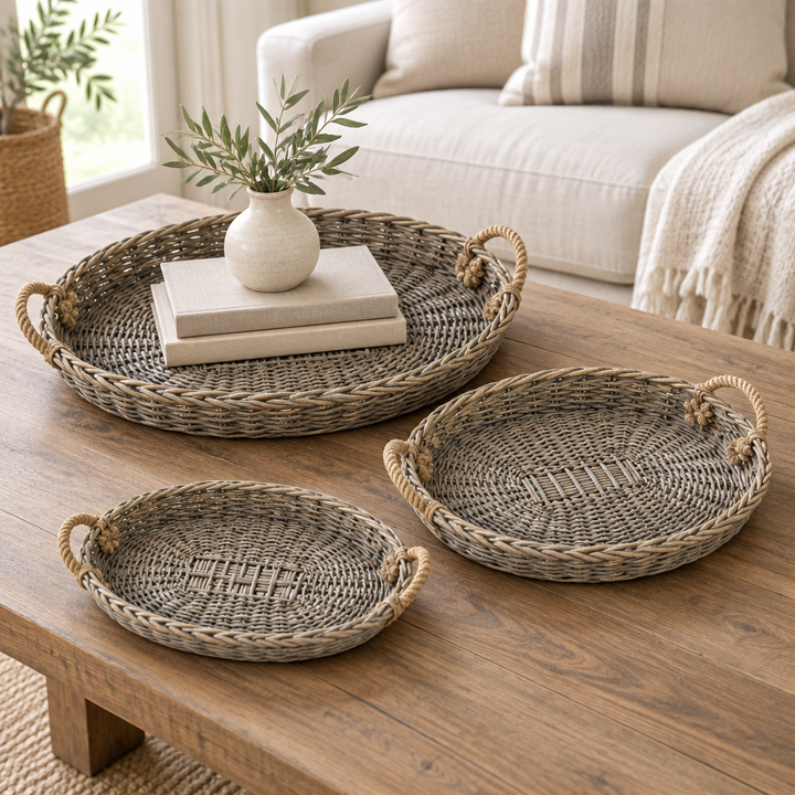 Oval willow trays with books and a small ceramic vase on a wooden coffee table