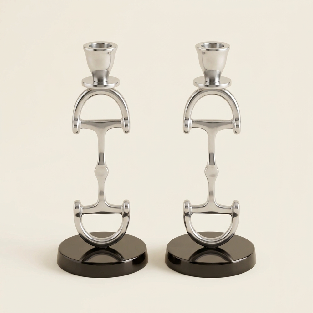 Pair of silver-finish D-bit candlesticks with open equestrian-inspired stems on an ivory background.