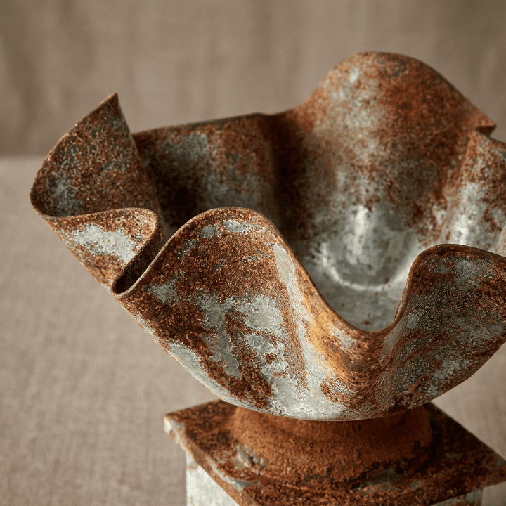 Close-up of the planter's folded handkerchief rim and distressed silver galvanized finish with rust-brown patina.