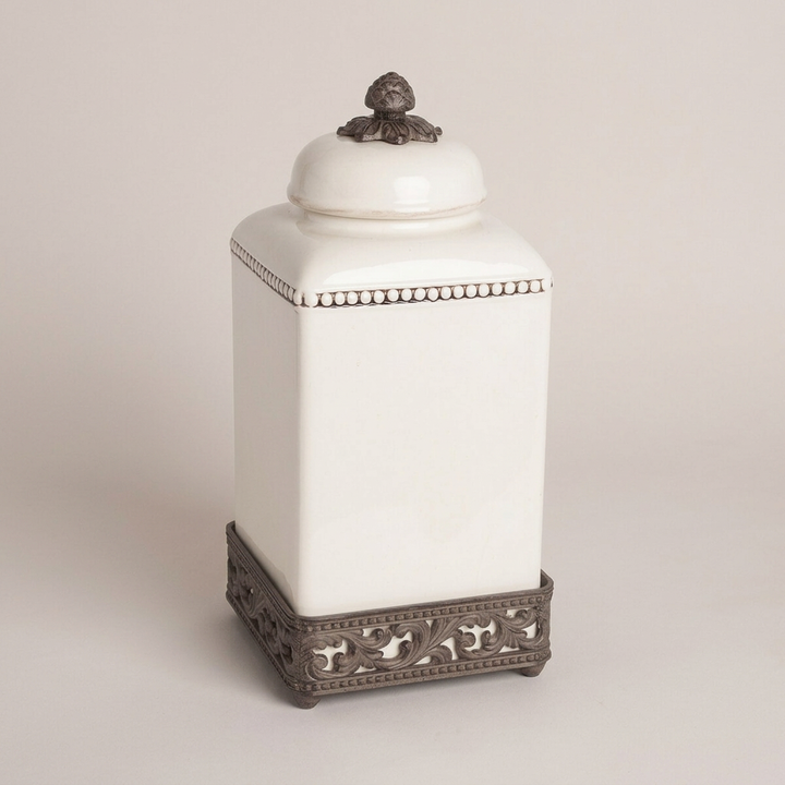 Tall Bellavita square canister with cream ceramic body and dark acanthus metal base.