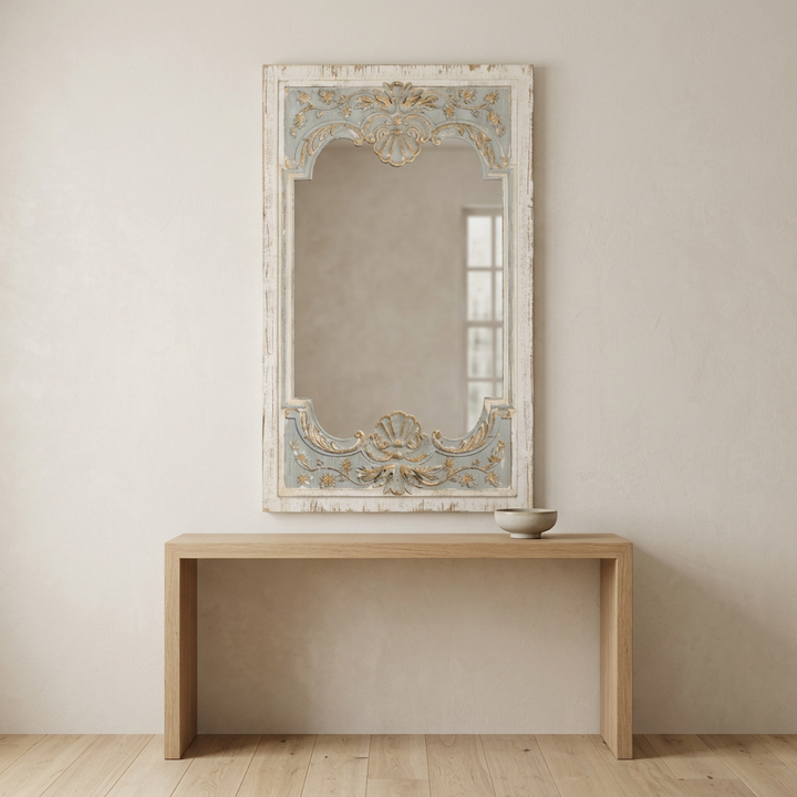 Avelune Carved Wood Mirror mounted above a natural oak console in a softly lit neutral entryway.
