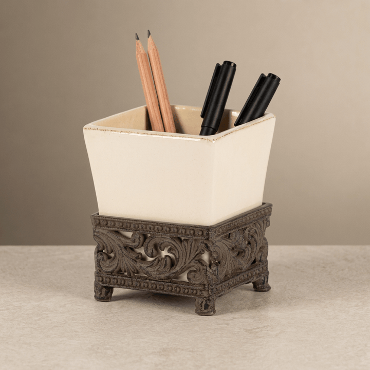 Bellavita pen holder with pencils and pens showing its cream square vessel and ornate brown acanthus base