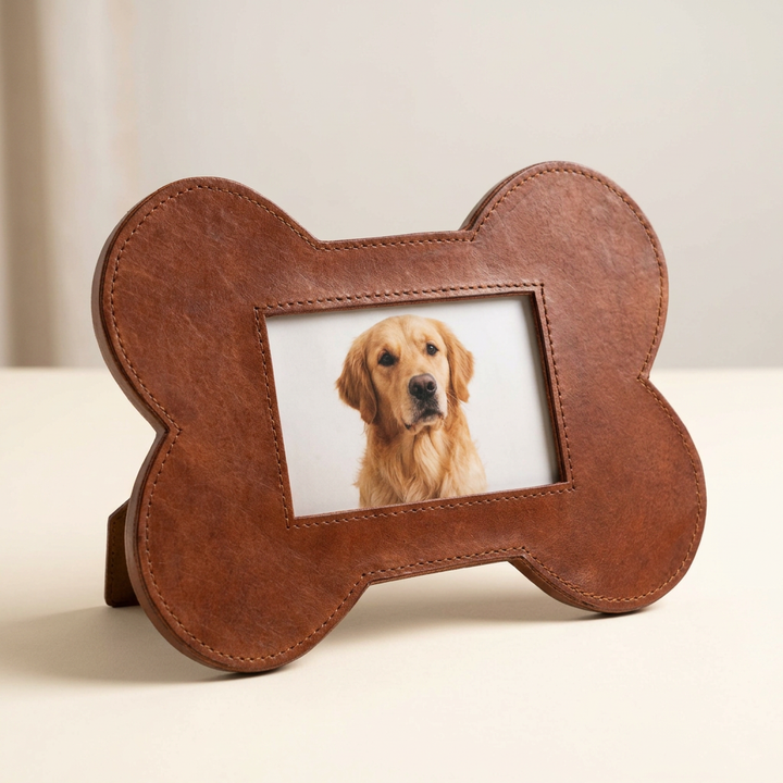 Brown leather bone-shaped photo frame displaying a golden retriever portrait on an ivory background.