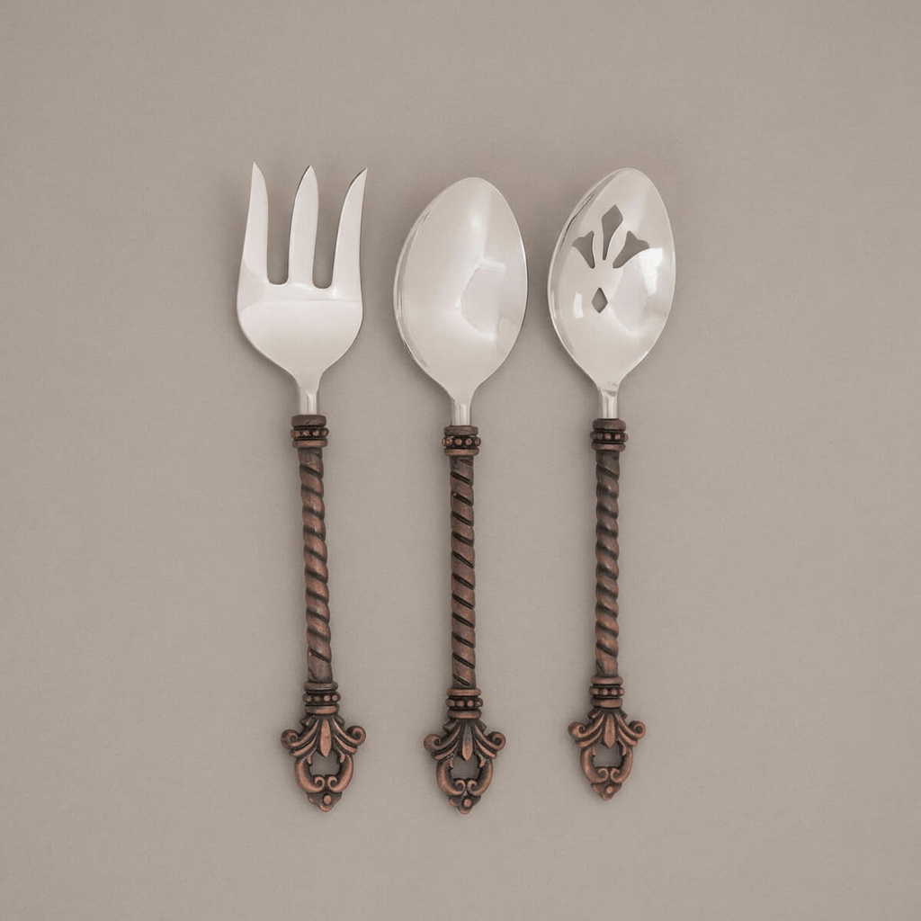 Full view of Bellavita serving fork and two serving spoons on a muted taupe background.
