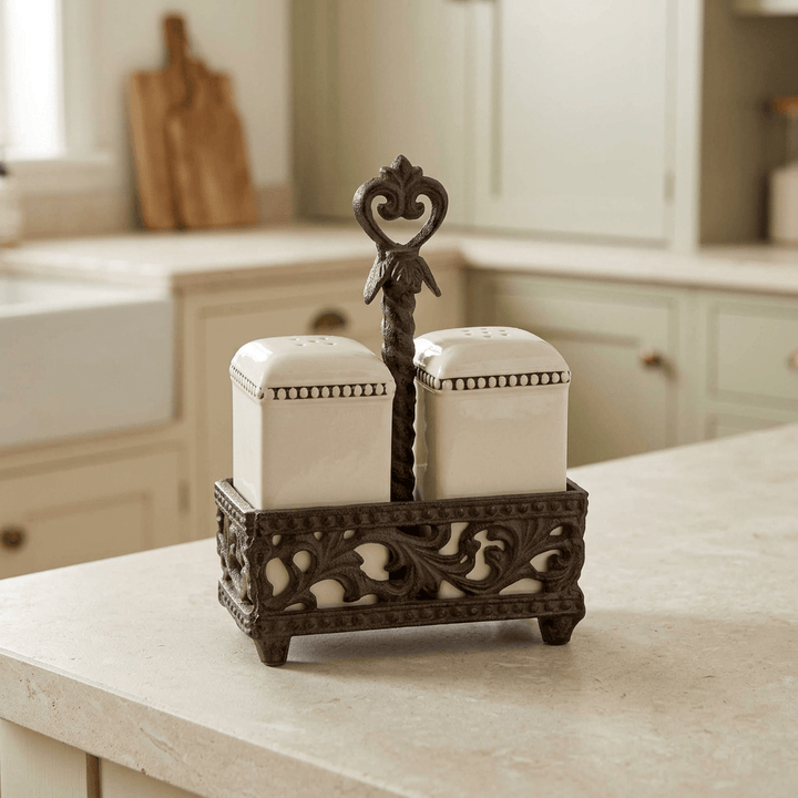 Bellavita salt and pepper shakers with ornate brown acanthus holder on a light kitchen countertop.