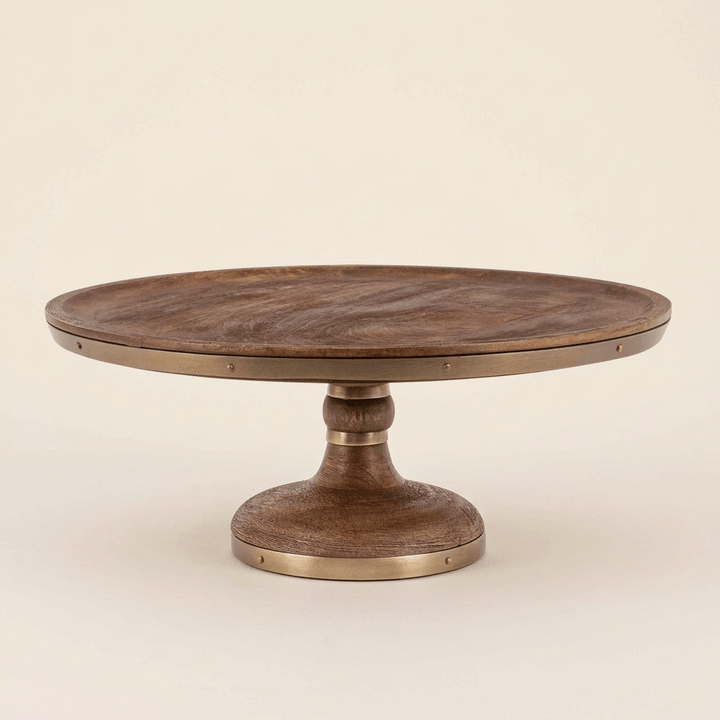 Aurelle mango wood cake stand with antiqued-gold metal bands against an ivory studio background