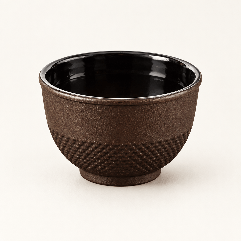 Single Brown Cast Iron Tea Cup on an ivory studio background