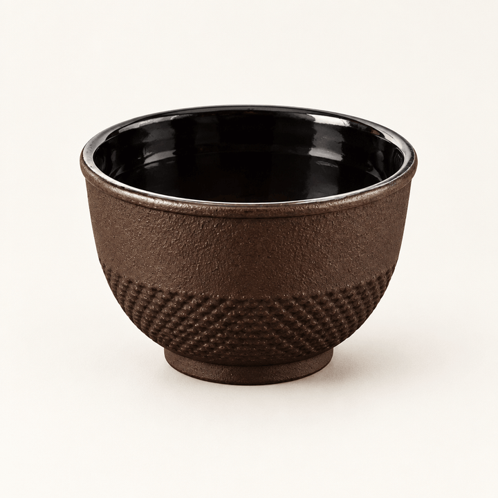 Single Brown Cast Iron Tea Cup on an ivory studio background