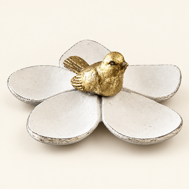 Distressed white five-petal jewelry dish with gold bird on an ivory background