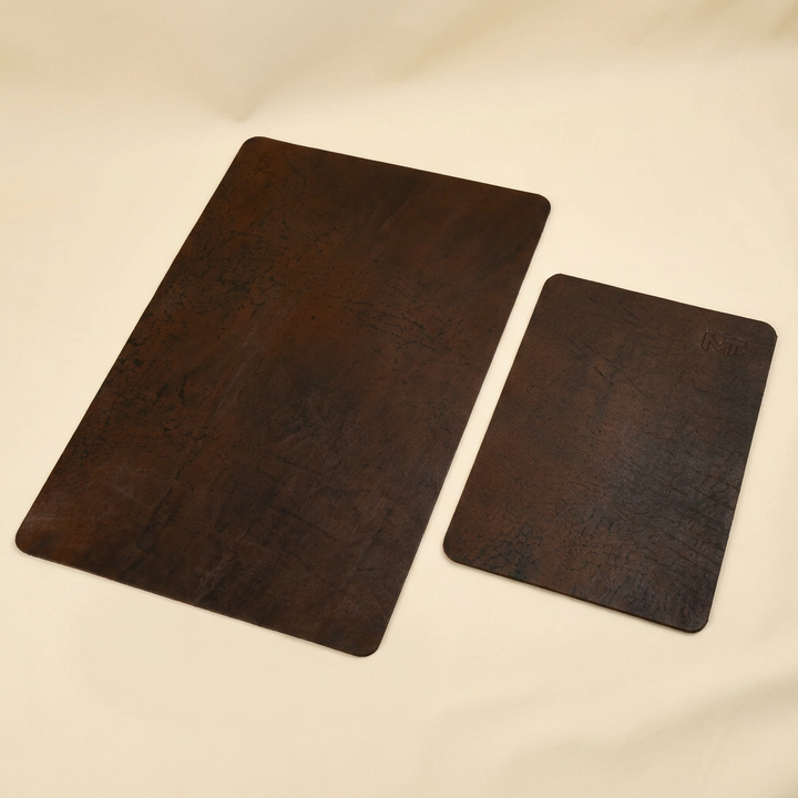 Espresso brown buffalo leather desk mat and matching mouse pad with rounded corners on an ivory background