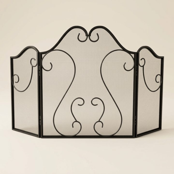 Black three-panel mesh fireplace screen with symmetrical scrollwork on an ivory studio background