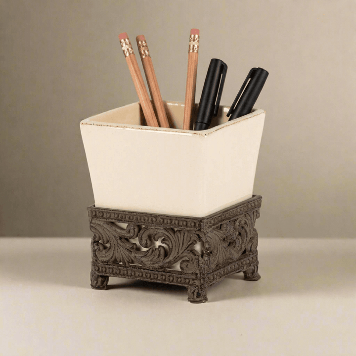 Bellavita cream ceramic pen and pencil holder with ornate dark-metal base styled with wood pencils and black pens
