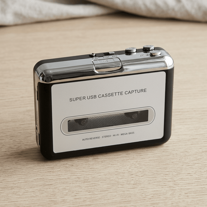 Silver-and-black portable cassette player and MP3 converter photographed from above on a pale oak tabletop.