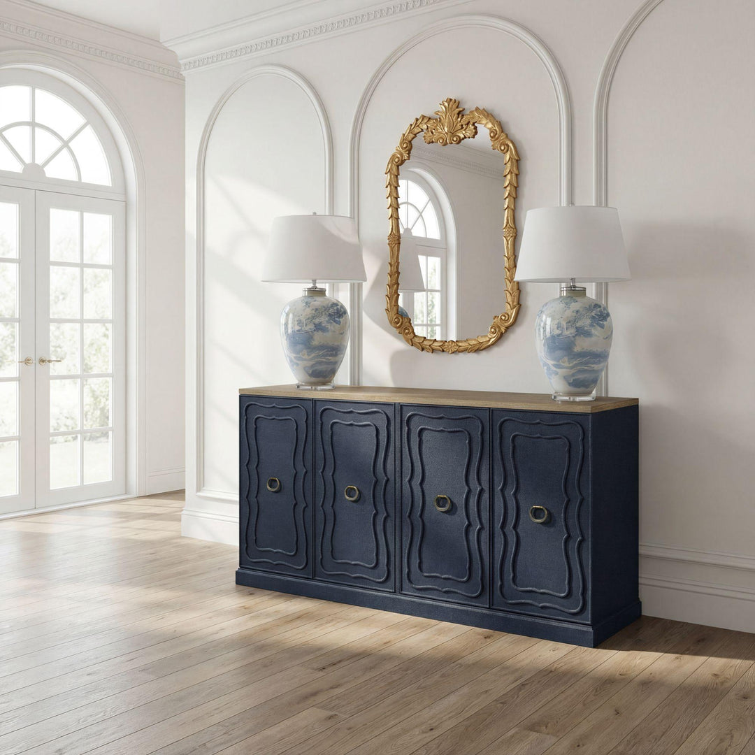 Indigo buffet styled beneath a gilt mirror with two table lamps; accessories not included.