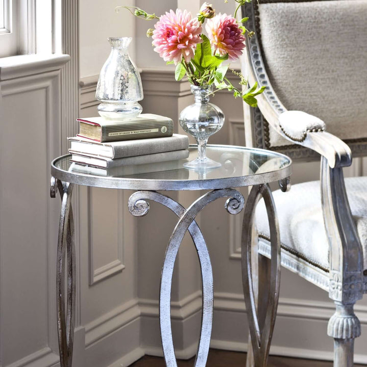 Italian Silver Leaf and Glass Side Table with antique silver finish and glass top, styled with flowers and books in an elegant setting.