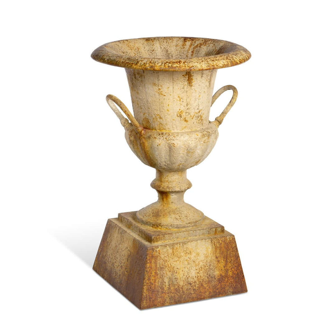 Large Rustic Metal Garden Urn with Aged Patina Finish beside wooden wall display