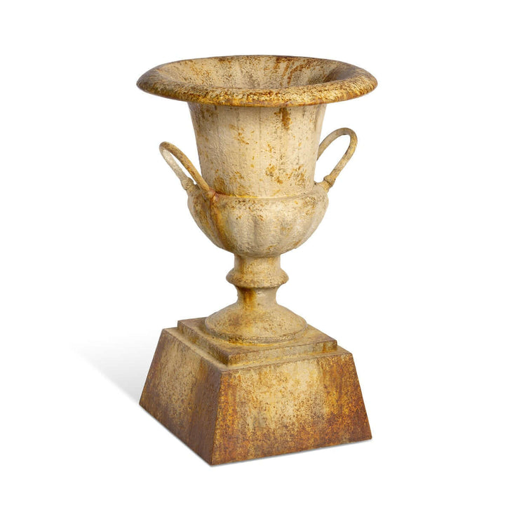 Large Rustic Metal Garden Urn with Aged Patina Finish beside wooden wall display
