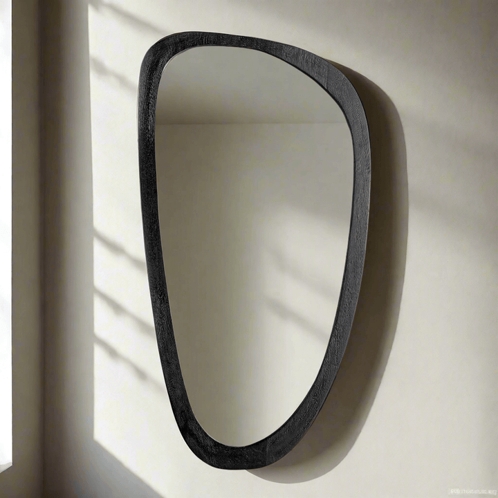 Asymmetrical black wood mirror with a sculptural design, embodying mid-century modern style.